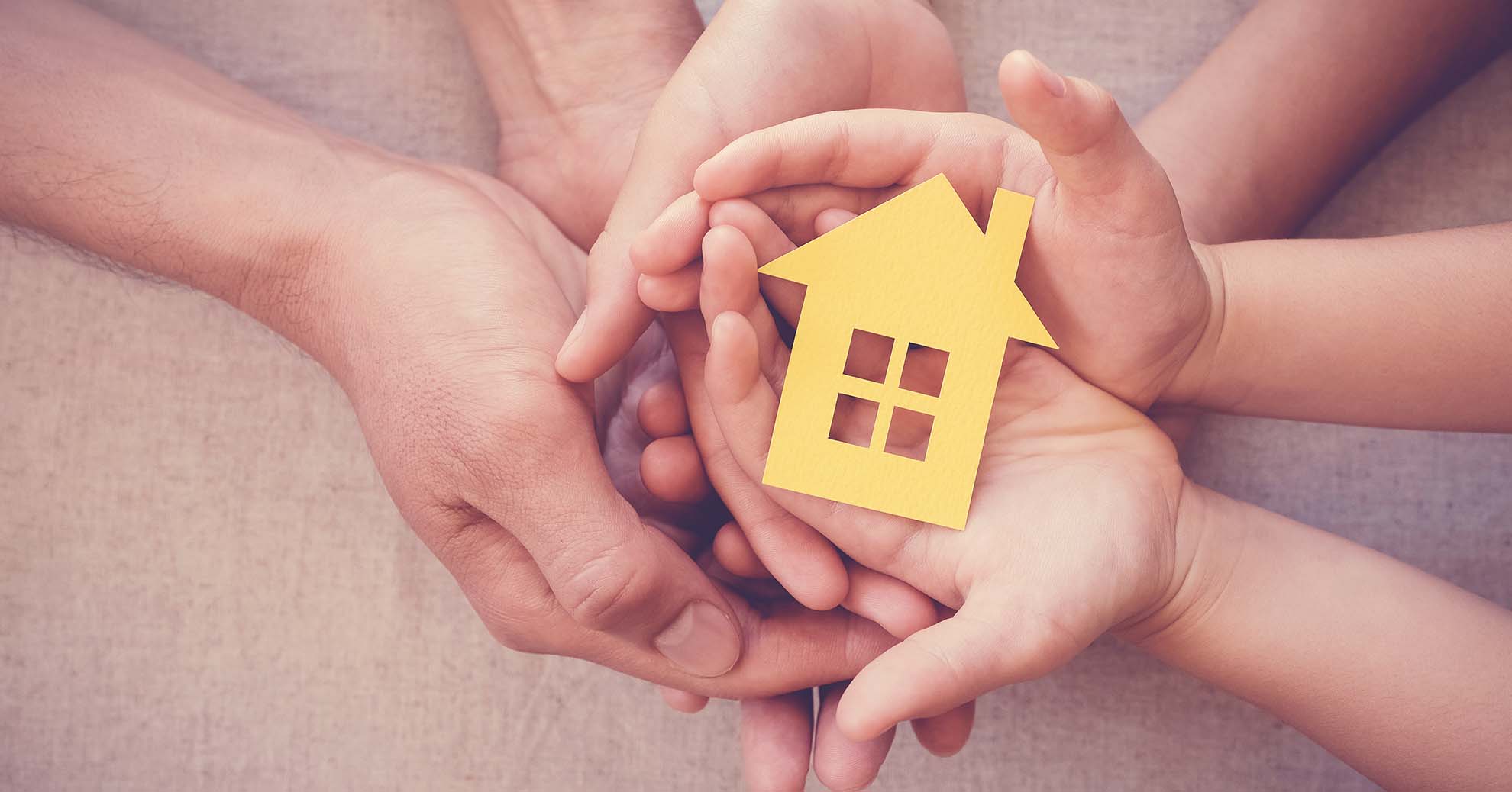 Hands holding a yellow house icon